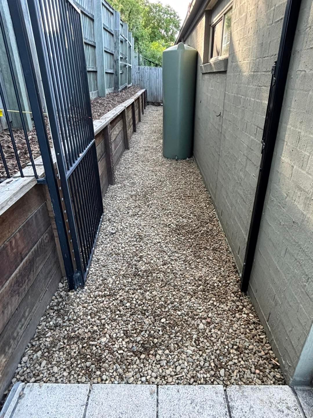 Completed gravel side path with timber retaining and a steel gate